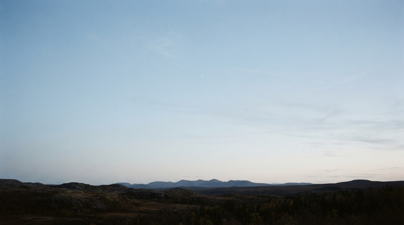 A wide view of a clear autumn sky with a single tiny bright dot hanging far off, its identity ambiguous