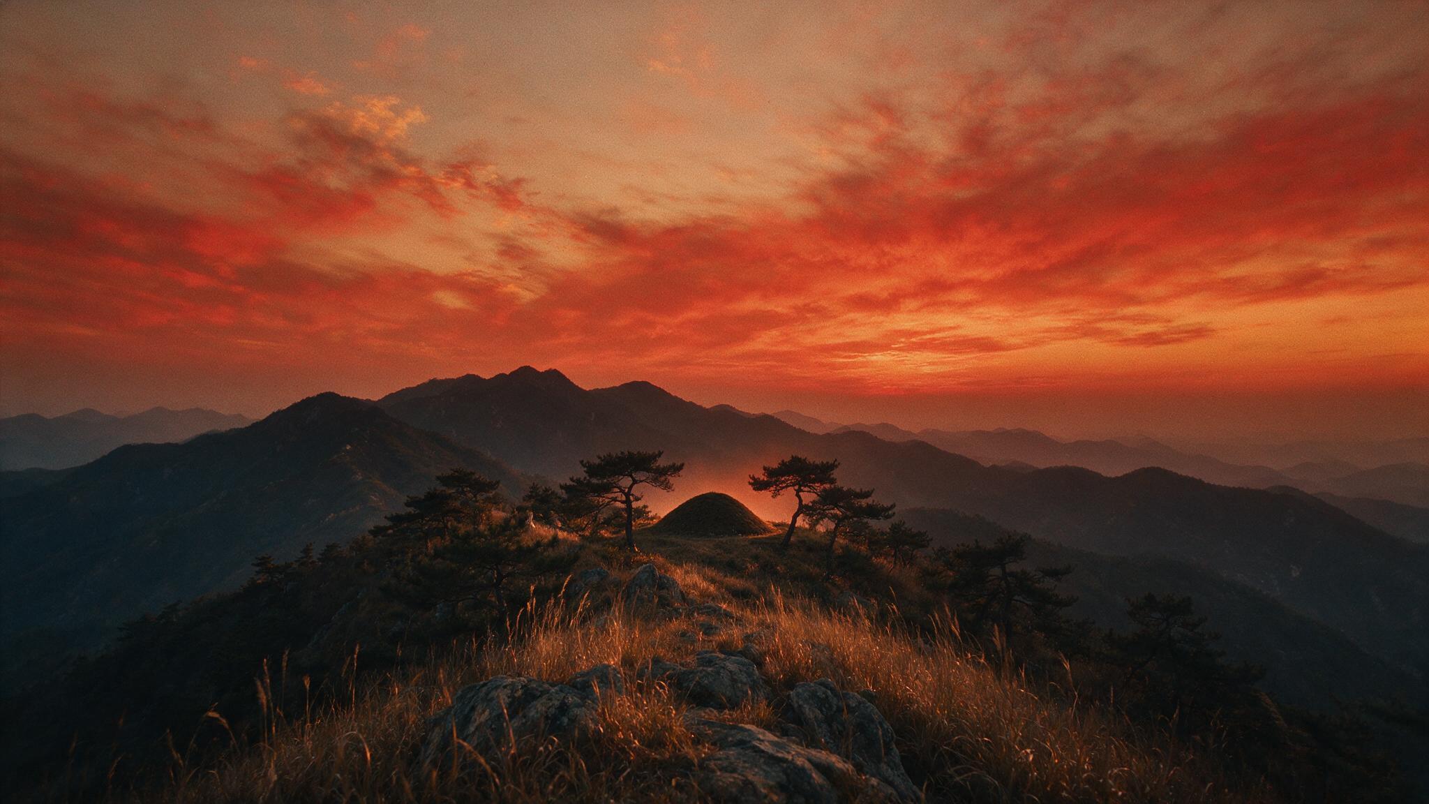 The red glow of sunset spreading beyond the ridgeline of Gayasan, the silhouette of a grave nestled on the mountainside, a grand and desolate aftertaste, no human faces