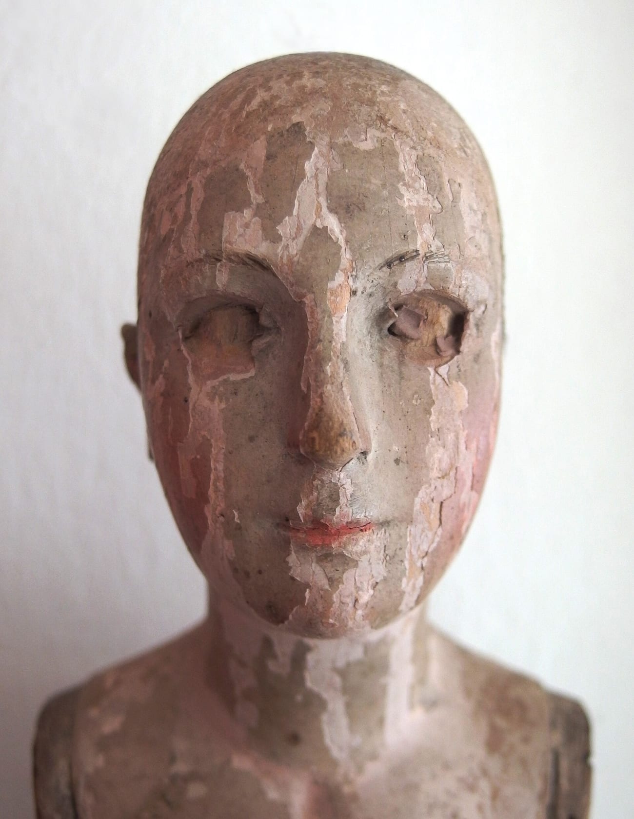 A weathered antique doll's face — the kind of aged, worn object at the heart of every haunted-doll story. (Jula2812 / CC BY-SA 4.0)