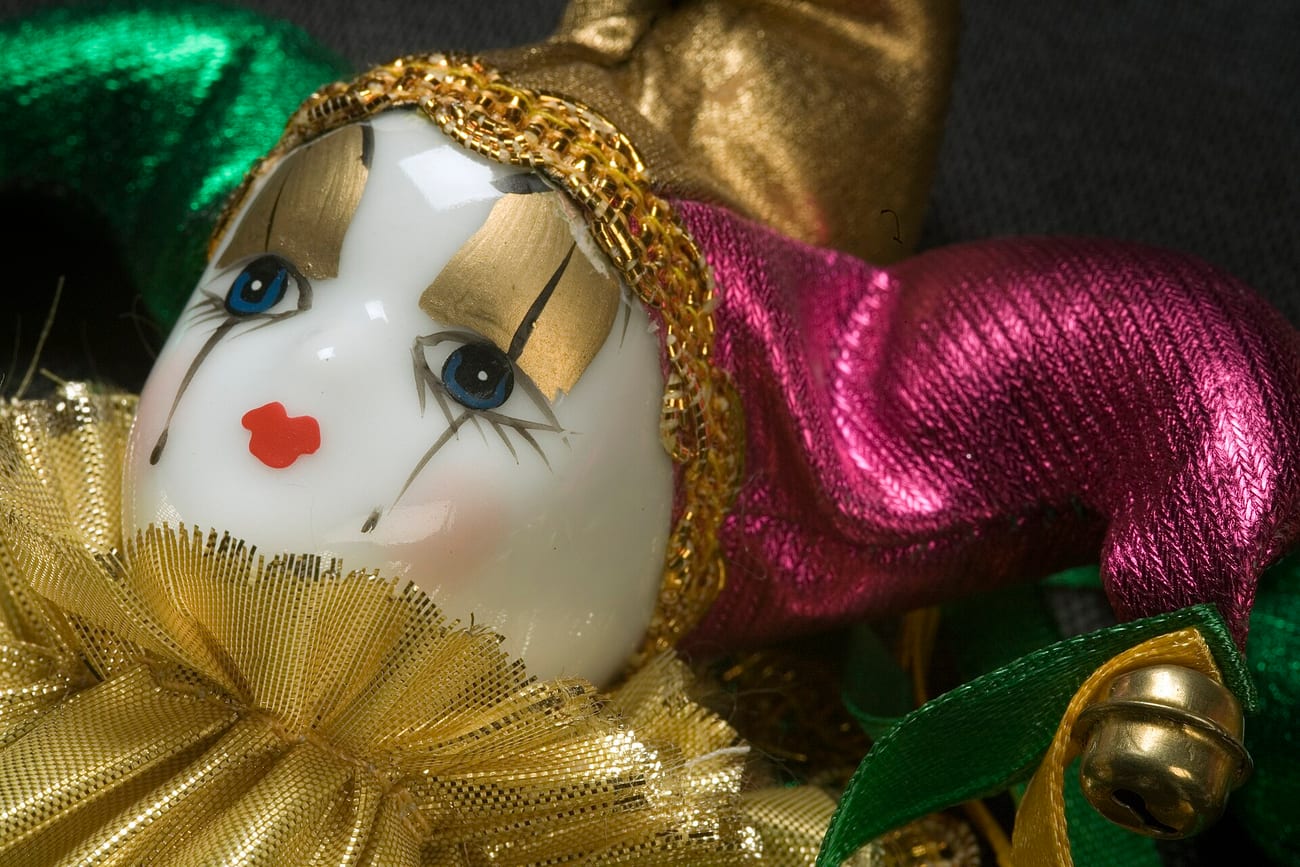 An old harlequin porcelain doll, its fixed painted smile unchanged for a century. (Jorge Royan / CC BY-SA 3.0)