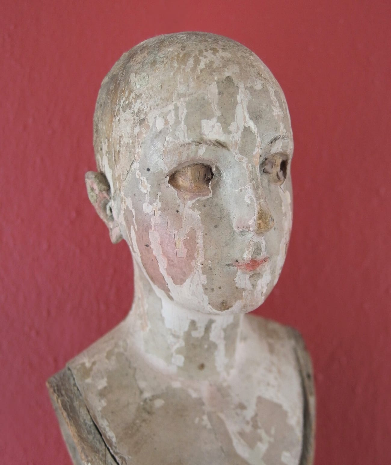 The portrait of an antique doll, its painted face cracked with age. (Jula2812 / CC BY-SA 4.0)