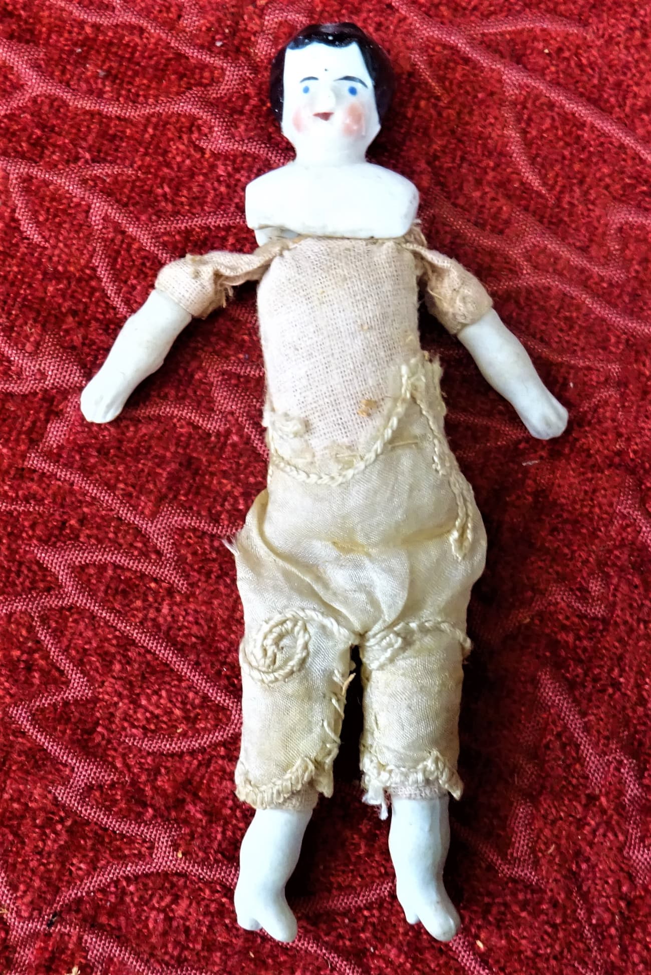 A tiny china-and-cloth Victorian doll, worn by the years. (Rosser1954 / CC BY-SA 4.0)