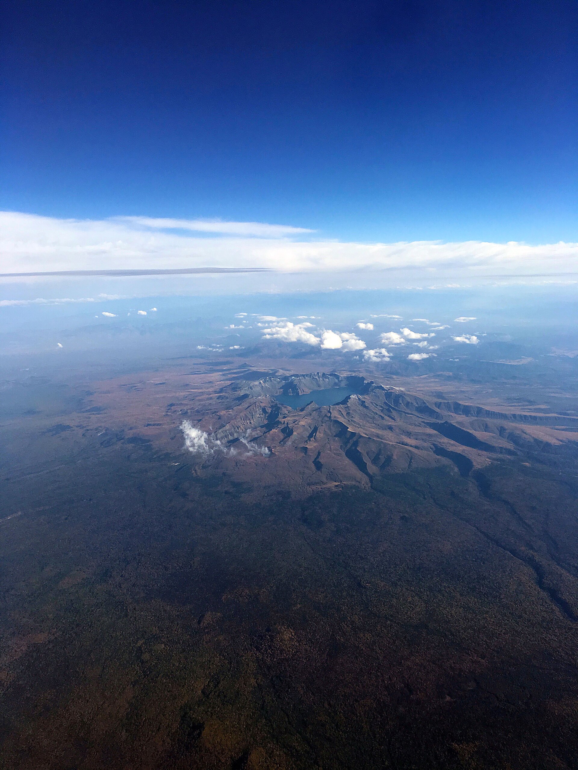 An aerial view of Heaven Lake, the caldera at the summit of Mount Baekdu — water pooled in the hollow the Millennium Eruption blew open.