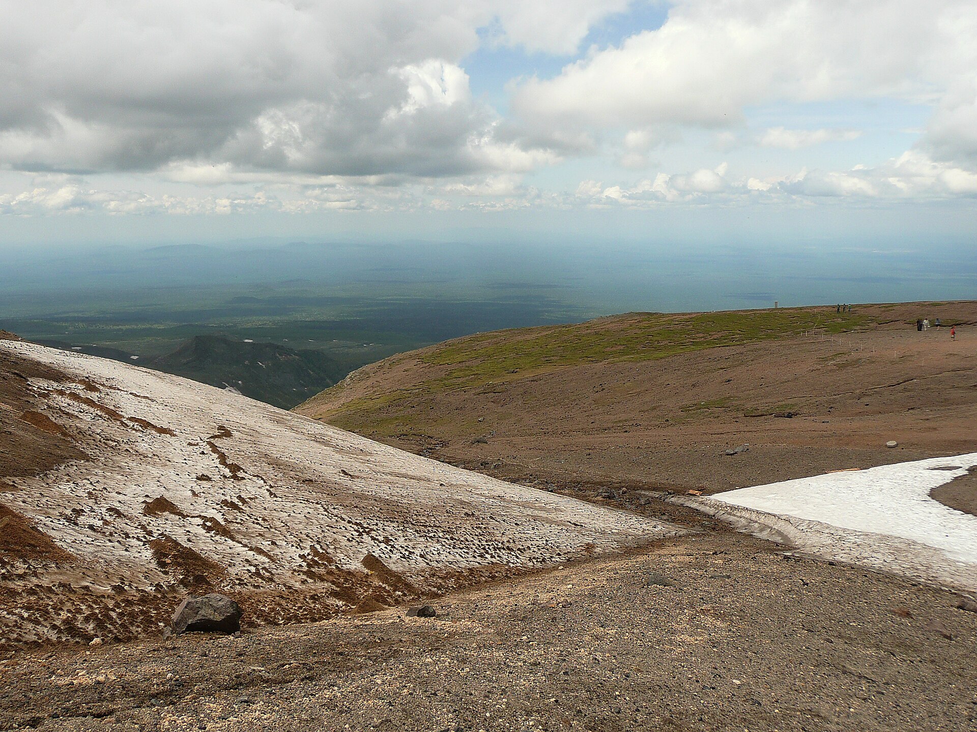 The upper slopes of Mount Baekdu today — pumice and ash piled in layers, with the volcanic plain spreading out below.