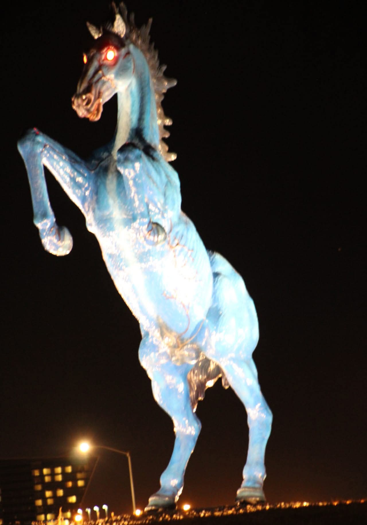The actual sculpture standing at the airport approach: 《Blue Mustang》, known to everyone as 'Blucifer' — its eyes glow red after dark