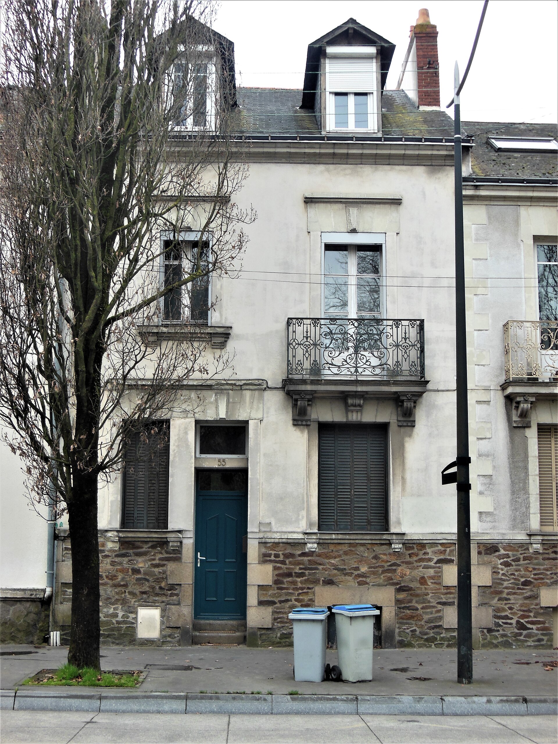 The front of the house at 55 boulevard Robert Schuman in Nantes: the number 55 on a blue-green front door, the ground-floor shutters closed. This is the house beneath whose rear terrace the family was found.