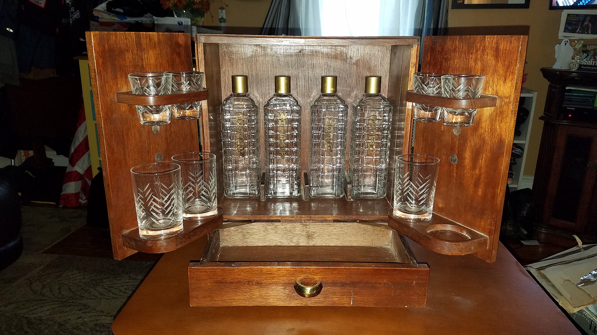A wine cabinet of the same type as the dybbuk box, standing open to show the fittings inside for bottles and glasses. This is not the box itself but a comparable replica, shown here to illustrate how such cabinets are built.