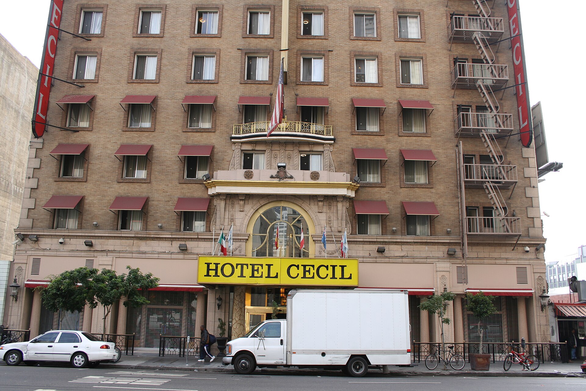 The front of the Cecil Hotel in downtown Los Angeles, its yellow HOTEL CECIL sign and red awning still in place.