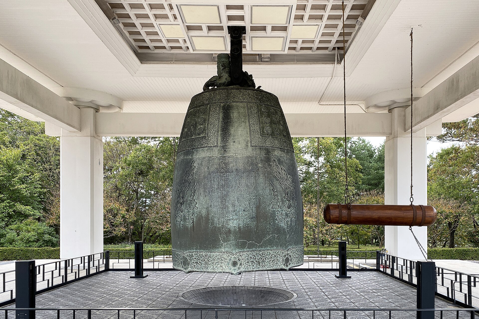 The Divine Bell of King Seongdeok seen head-on in its pavilion at the Gyeongju National Museum, with the wooden striker beam at right