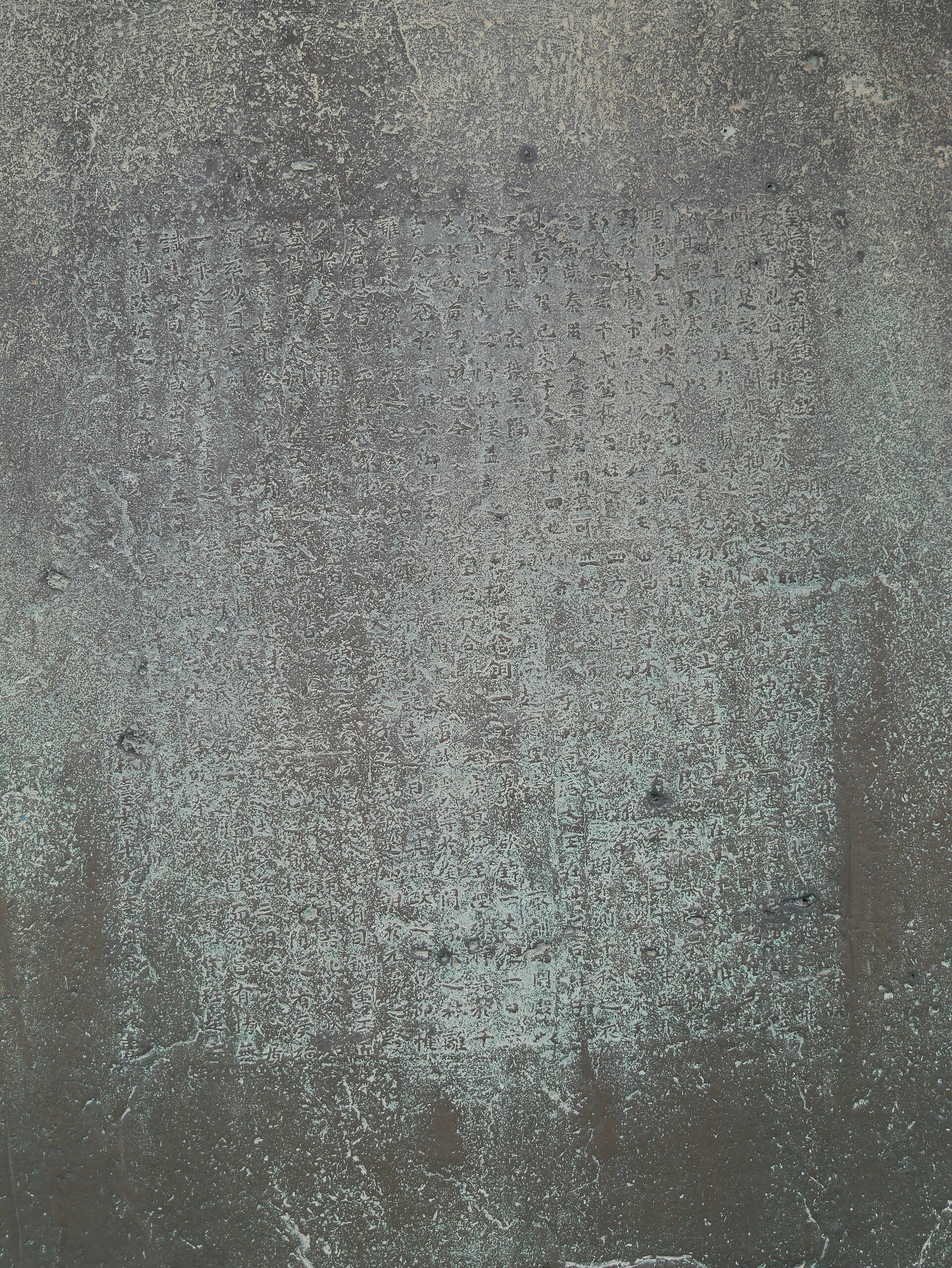 Close-up of the cast inscription on the bell — nearly a thousand characters wrapped around its body