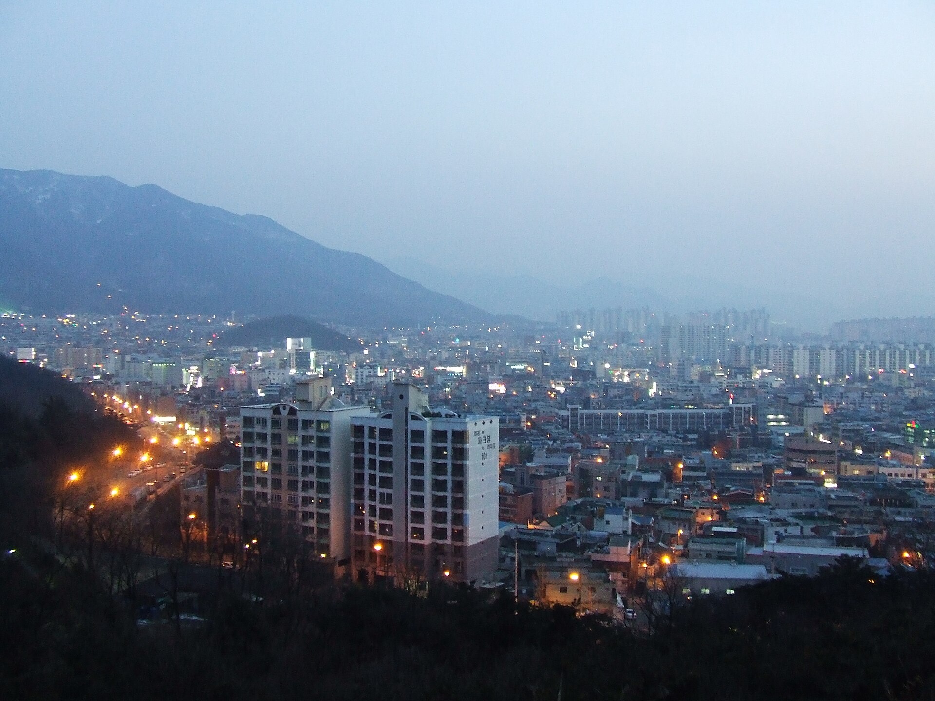 Dalseo-gu, Daegu at dusk with the mountain ridge behind it — the area the five boys set out from, as it looks today