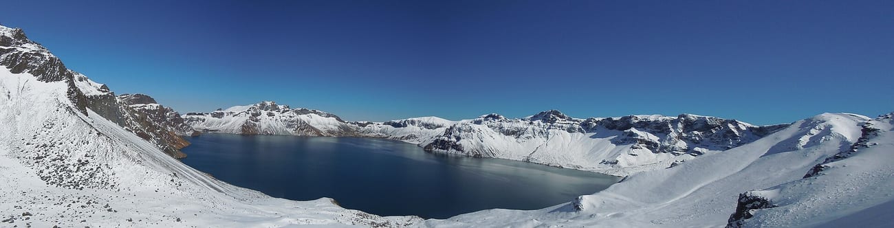 A panorama of the lake ringed by the volcano's jagged caldera rim. (Sinopitt / CC BY-SA 3.0)