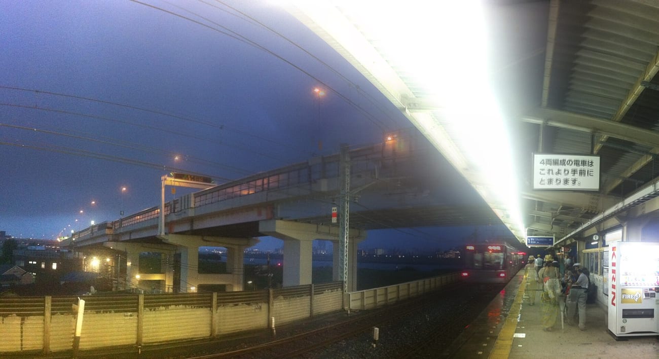 An empty small-town station platform on a rainy night. (Kosuge Station, illustrative. nesnad / CC BY 3.0)