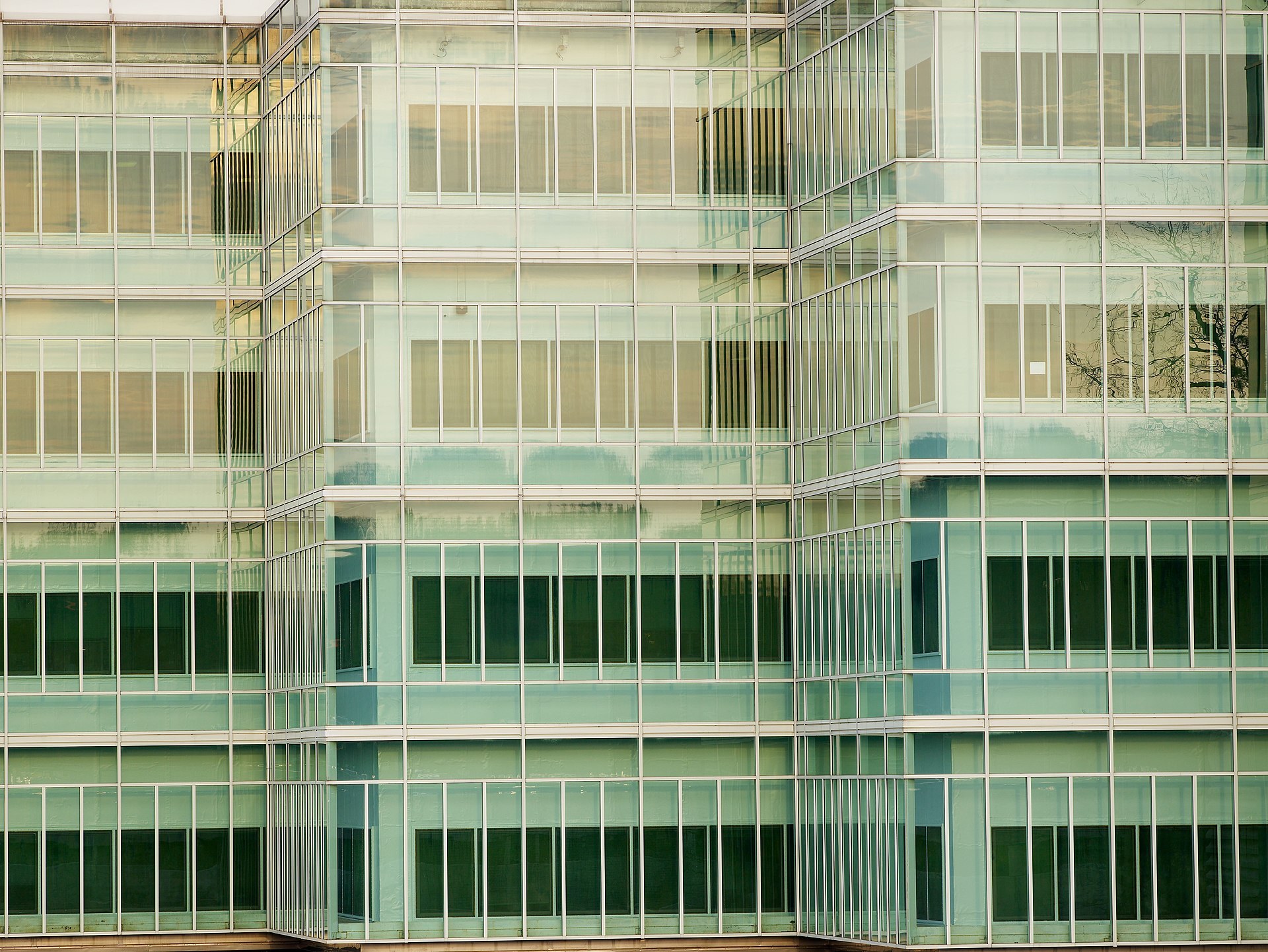 The glass facade of the CIA's New Headquarters Building. The sculpture stands in the courtyard behind it.