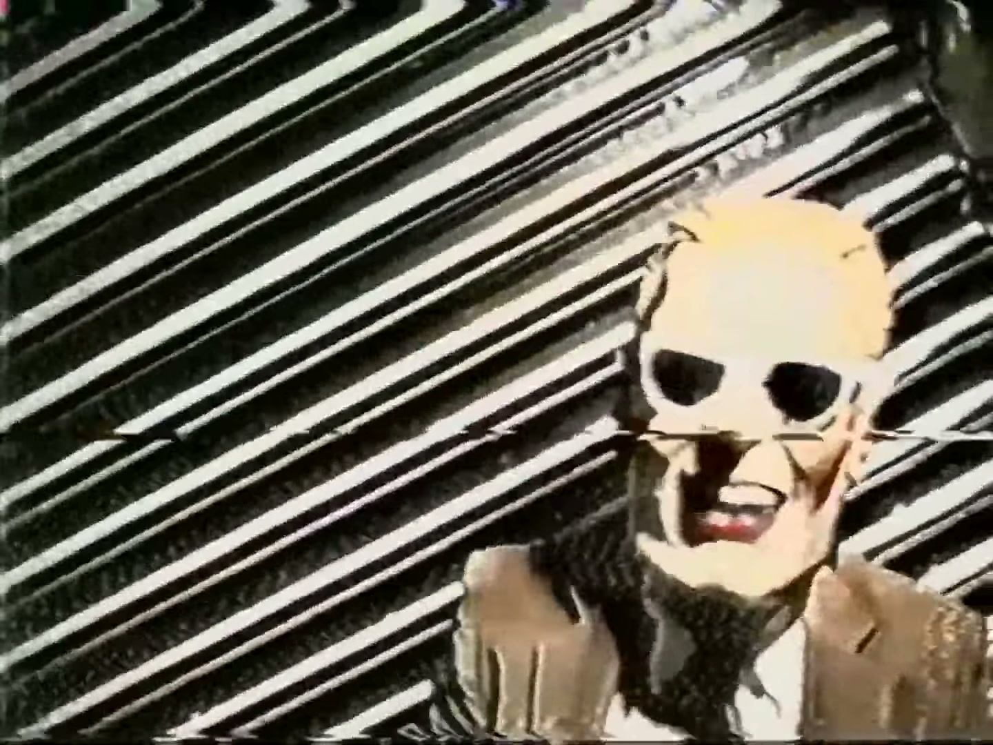 An actual capture from later in the intrusion — the masked figure in close-up as the signal degrades into heavy distortion and noise