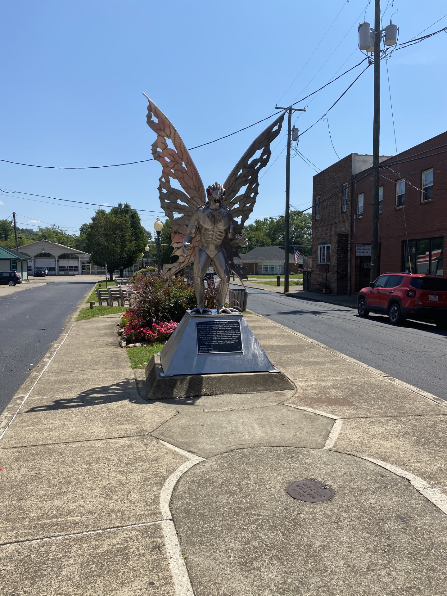 The full metal Mothman statue standing on a median in downtown Point Pleasant, wings spread wide in the middle of the street