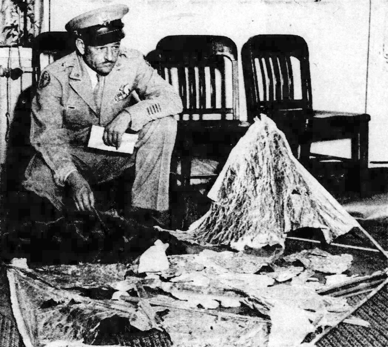 1947年7月8日、報道陣に残骸を示しながら例の有名なメモを手にするロジャー・レイミー将軍。 (J. Bond Johnson / Public domain)