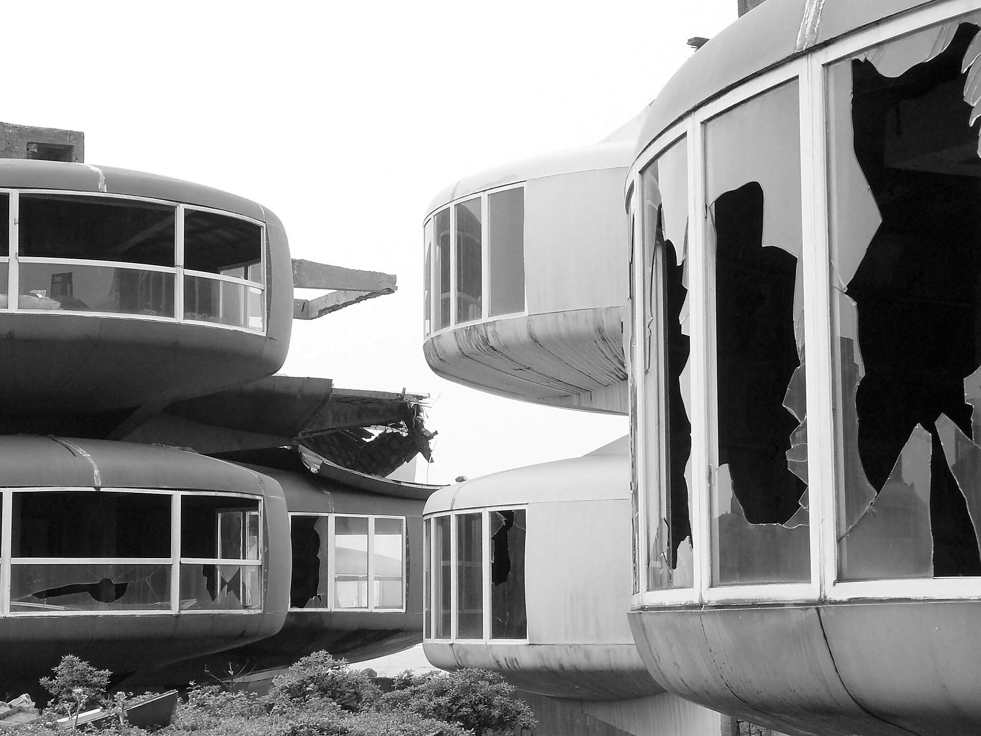 A cluster of pod houses with every pane of glass smashed out (Wikimedia Commons)